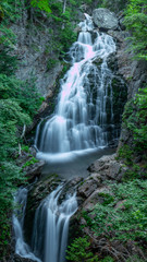 Long exposure crystal waterfall in the White Mountains of New Hampshire. Waterfall flowing into pool of water long exposure.