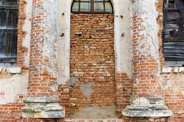 wall of an abandoned building, the entrance to which is bricked up, and the windows are boarded up © Вячеслав Думчев