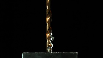Slow motion close up, drill bit drills metal