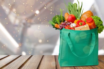 Full shopping  bag on table on wall background