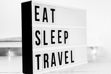 Eat sleep travel quote on a wooden white background. Motivational business start up board