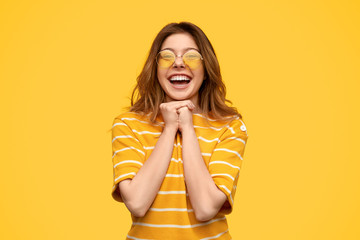 Delighted stylish woman clasping hands