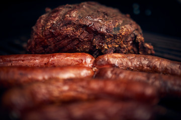 Grilled meats over the barbecue fire. You can see the smoke, the fire and the heat as well as the fiery ones of the melted fats when falling under the direct fire