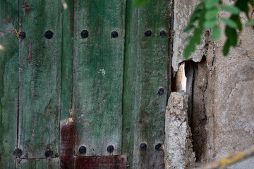 old green wooden door in an abandoned forest house