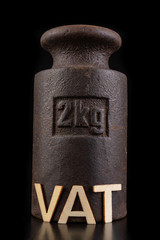 Vat inscription and old weight 2 kg. Office and shop accessories on a dark table.