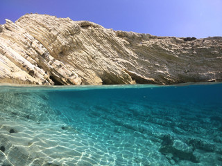 Above and below underwater photo of crystal clear sea paradise rocky seascape of Laki beach in Kato Koufonisi island, Cyclades, Greece