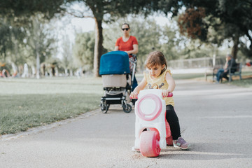 Little Girl playing with a toy motorbike