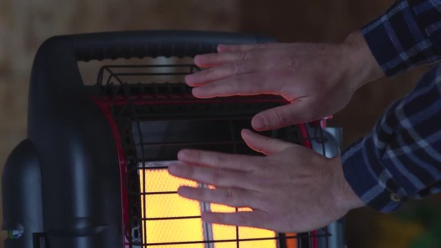 Hands warm near portable heater