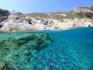 Above and below underwater photo of crystal clear sea paradise rocky seascape and small chapel of...