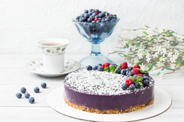 Vegan raw cake with raspberries and blueberries.  Healthy vegan food concept. Sugar, dairy and gluten free dessert.