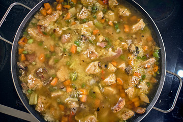 preparation of rice with chicken in Latin style with vegetables, broccoli, peas, carrots, white rice