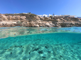 Fototapeta na wymiar Above and below underwater photo of crystal clear turquoise sea paradise beach of Ammos and main town - port of Koufonisi island, Small Cyclades, Greece