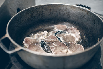 fish frying in a pot in boiling edible oil