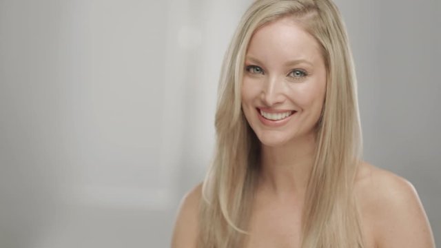 Caucasian blonde woman in studio smiling and laughing at camera