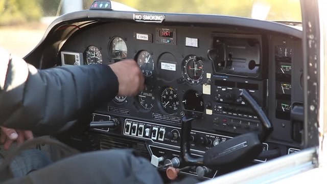 Caucasian pilot in airplane cockpit adjusting knobs