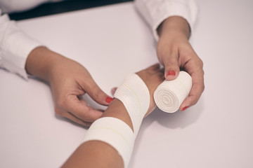 a woman's arm is bandaged with a white bandage and a first aid aid