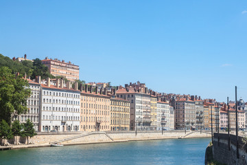 Fototapeta na wymiar Panorama of Saone river and the Quais de Saone riverbank and riverside in the city center of Lyon, with a focus on the old building facades of the Presqu'Ile, also called Peninsula