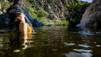 Young girl splashing hair in Mojave river