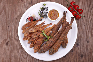 Fried fish on a white plate, on a board. Bulls, Barabola