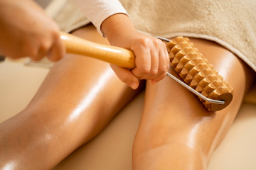 Anti cellulite massage with wooden tool closeup  - obrazy, fototapety, plakaty