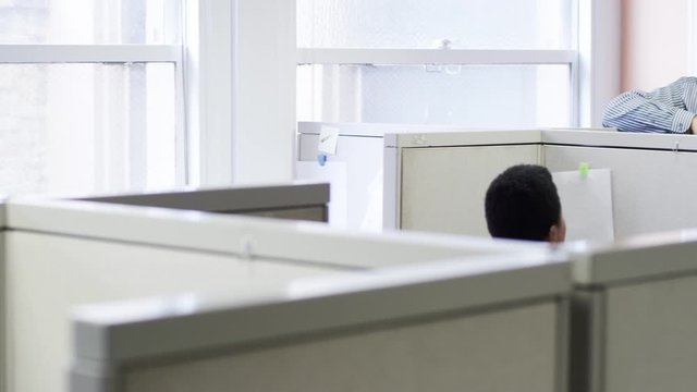 Business people laughing in meeting at office cubicles