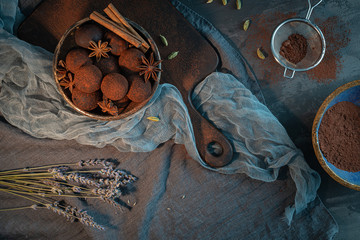 Craft chocolate truffles on bowl with cocoa powder, anise, cinnamon and cardamom