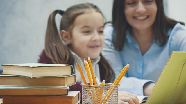 Mother becoming frustrated with daughter whilst doing homework sitting at the table at home in learning difficulties homework.