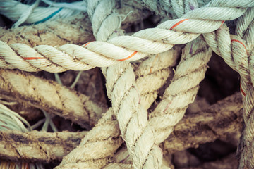 Nautical background of a detail of old frayed boat rope twisted in a pile.