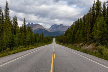 Fototapeta na wymiar Scenic road in the Canadian Rockies during a vibrant sunny and cloudy summer morning. Taken in Icefields Parkway, Banff National Park, Alberta, Canada.