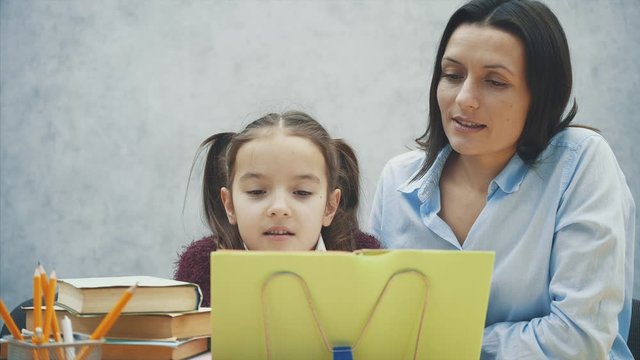 Mother becoming frustrated with daughter whilst doing homework sitting at the table at home in learning difficulties homework.