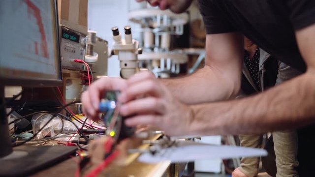 Worker adjusting wiring on robotics circuit boards