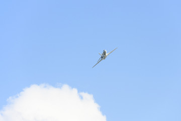 Stunning view of a private white jet flying in a blue and cloudy sky. Business jets is a jet plane used to transport groups of businessmen or wealthy people.
