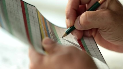 Hands of golfer writing on scorecard