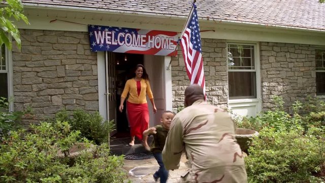 Extended family welcoming military man returning home