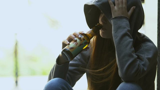 Sad teenager taking beer bottle from female hand, bad street influence addiction
