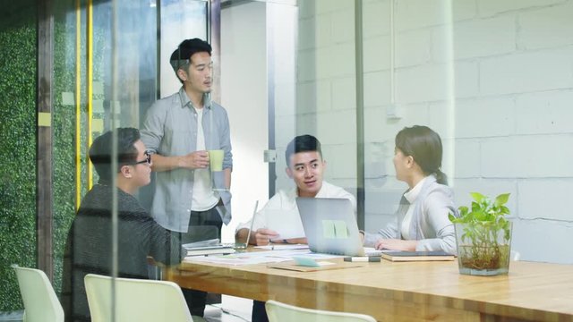 group of young asian entrepreneurs meeting in office discussing business plan