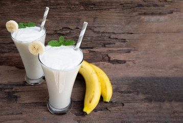 Banana fresh cocktail vanilla smoothies juice white fruit beverage healthy the taste yummy In glass for milkshake on wooden background.
