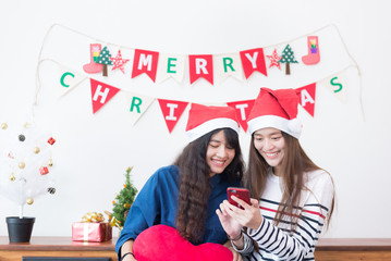 Young asian woman shopping online on a smartphone for buy christmas gift at home.