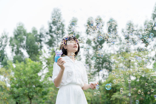 woman playing with soap bubbles machine