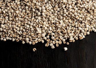 dried pearl barley on wood background..