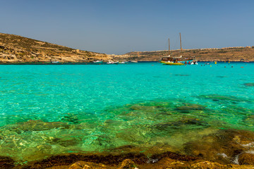 View of Blue Lagoon, located on Malta's smallest inhabited island Comino, with its clear turquoise shallow waters, golden rocks and dramatic coastline