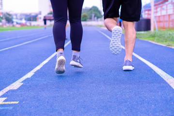 Closeup shoe. A couple jogging and walking together on the running track. Sport and exercise concept.