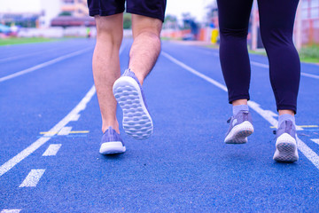 Fototapeta na wymiar Closeup shoe. A couple jogging and walking together on the running track. Sport and exercise concept.