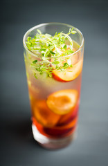 Cocktail with plums and thyme on the rustic background. Selective focus. Shallow depth of field.