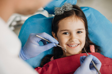 Close up of a happy little girl looking at camera before teeth examination in a pediatric stomatology.