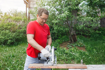Carpenter with electric disc saw.