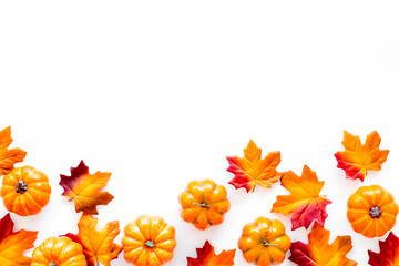 Fototapeta premium Autumn background with leaves and pumpkins on white top view space for text frame