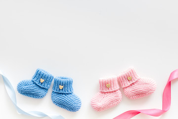 Blue and pink knitted footwear for kids on white background top view space for text
