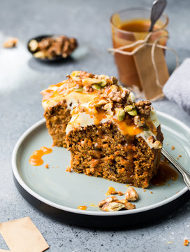 Carrot cake (bread, pie) with nuts, cheese cream and salted caramel. Favorite delicious coffee cake