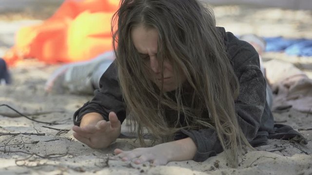 Lost female plane crash victim on ocean shore coughing and spiting out water